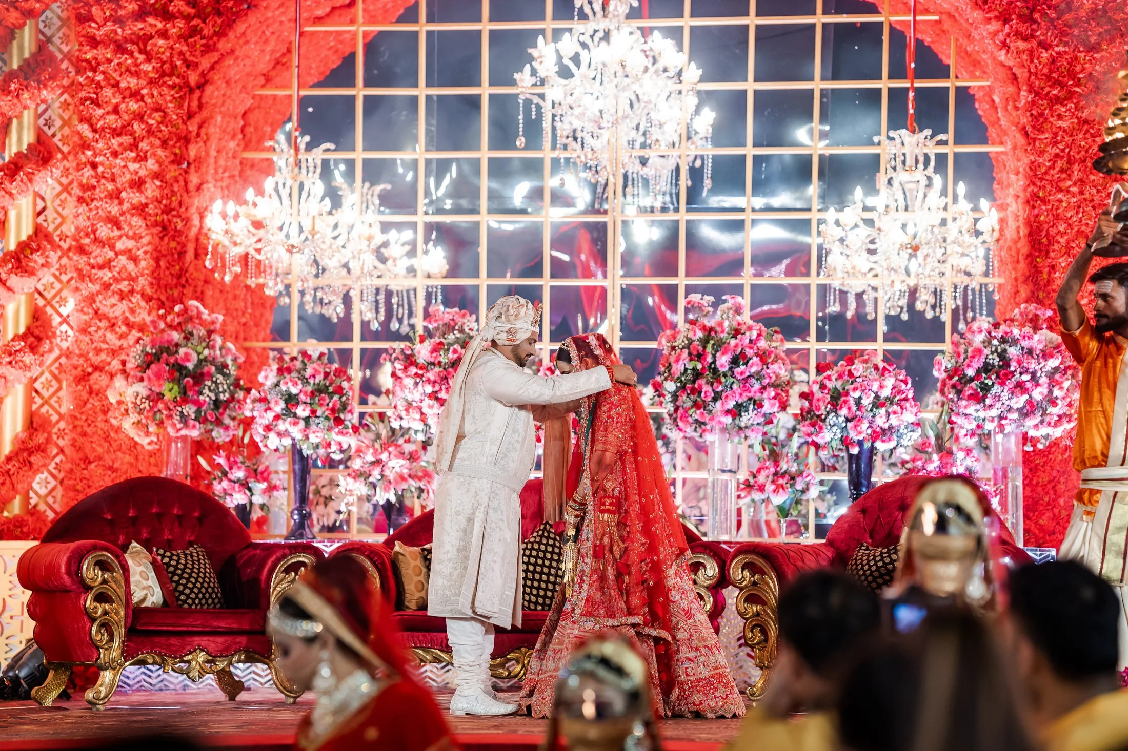 Groom veiling the bride on a floral stage